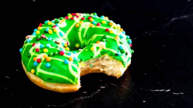 Yeşil jöleli donut ve serpiştirilmiş. Isırılmış renkli çörekleri kapat..