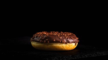 Çikolata kaplı çörek ve çikolata parçacıkları izole edilmiş. Lezzetli çörekleri yakın çekin..