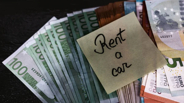 Sticky note on money. Text Rent a car on post it. Bucharest, Romania, 2020