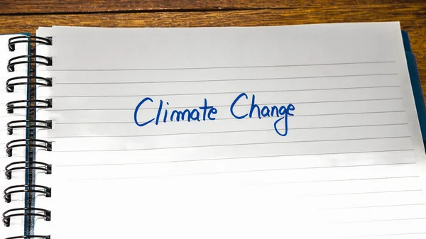 Climate change handwriting  text on paper, on office agenda. Copy space.