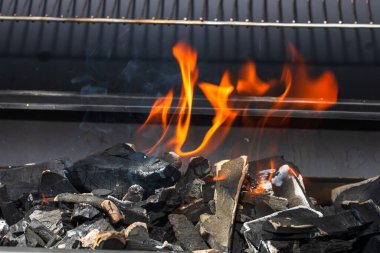 Işıl ışıl yanan ızgara ocağı. Kırmızı alevler, kömür kömürleri ve közlerle birlikte.