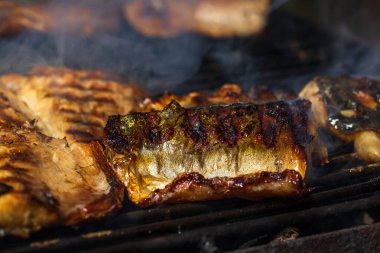 Kömür ızgarasında ızgara uskumru ve duman..