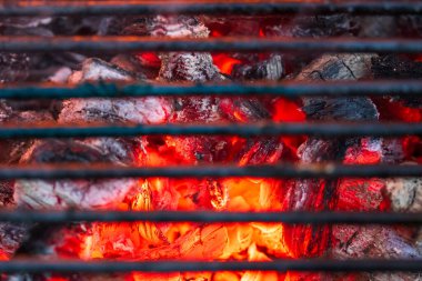 Parlayan ve yanan kömür briketleriyle barbekü ocağı.