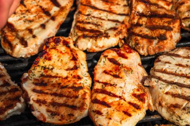 Izgara domuz bifteği. Lezzetli biftekler ızgarada yakın pişiyor.