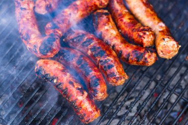 Kömür mangalında ızgara sosis. Lezzetli barbekü, yemek konsepti, ızgaradaki yemek ve ızgaradaki sosislerin ayrıntıları.