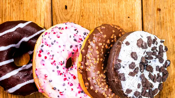 Masada fotokopi alanı olan renkli çörekler. İzole edilmiş donutların üst görünümü.