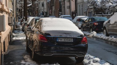 Romanya 'nın Bükreş kentinde kışın ilk günü, karla kaplı arabalar