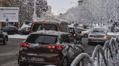 Romanya 'nın Bükreş kentinde kışın ilk günü, karla kaplı arabalar