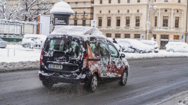 Romanya 'nın Bükreş kentinde kışın ilk günü, karla kaplı arabalar