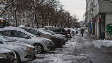 Romanya 'nın Bükreş kentinde kışın ilk günü, karla kaplı arabalar