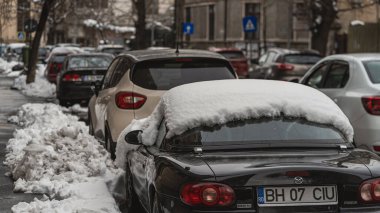 Romanya 'nın Bükreş kentinde kışın ilk günü, karla kaplı arabalar