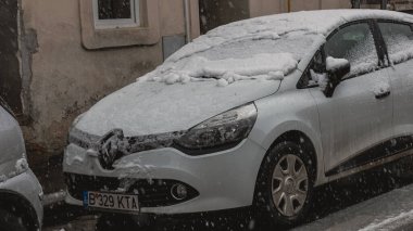 Romanya 'nın Bükreş kentinde kışın ilk günü, karla kaplı arabalar