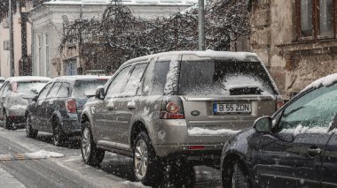 Romanya 'nın Bükreş kentinde kışın ilk günü, karla kaplı arabalar