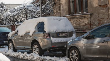 Romanya 'nın Bükreş kentinde kışın ilk günü, karla kaplı arabalar