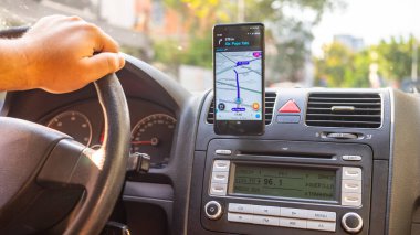 Şehirdeki yolu göstermek için Waze haritalarını gösteren akıllı telefon. Waze haritaları kullanan sürücü