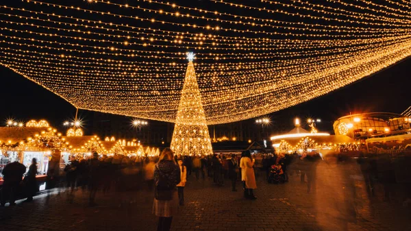 布加勒斯特圣诞市场圣诞树前的人们 图库图片