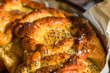 Örülmüş poğaça üzerine tuz ve haşhaş tohumlarının detaylarına odaklanmış seçici bir fotoğrafla kapat..