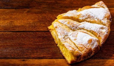 Tahtaya şeker tozu sürülmüş taze pişmiş elmalı turta. Ev yapımı elmalı pasta..