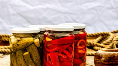 Kırmızı biber turşulu cam kavanozlar ve izole edilmiş salatalık turşusu. Çeşitli sebze turşulu kavanozlar. Kaba bir kompozisyonda yiyecek konseptini korudu.