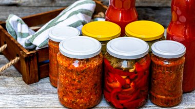 Kırmızı biber turşulu cam kavanozlar ve izole edilmiş salatalık turşusu. Çeşitli sebze turşulu kavanozlar, zakuskalı kavanozlar ve domates soslu şişeler. Korunmuş gıda konsepti.