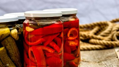 Kırmızı biber turşulu cam kavanozlar ve izole edilmiş salatalık turşusu. Çeşitli sebze turşulu kavanozlar. Kaba bir kompozisyonda yiyecek konseptini korudu.