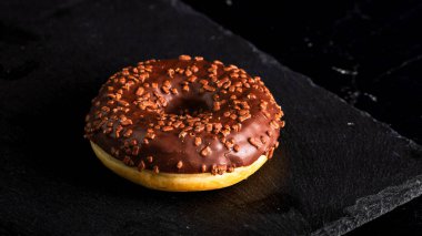 Çikolata kaplı çörek ve çikolata parçacıkları izole edilmiş. Lezzetli çörekleri yakın çekin..