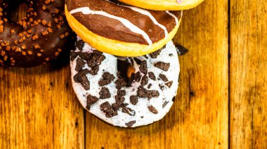Masada fotokopi alanı olan renkli çörekler. İzole edilmiş donutların üst görünümü.