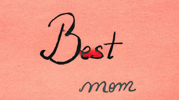 Best mom ever handwriting text close up isolated on orange paper with copy space. Writing text on memo post reminder