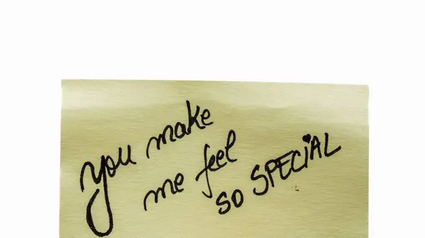 You make me feel so special handwriting text close up isolated on yellow paper with copy space.