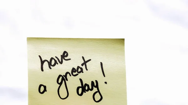 Have a great day handwriting text close up isolated on yellow paper with copy space.