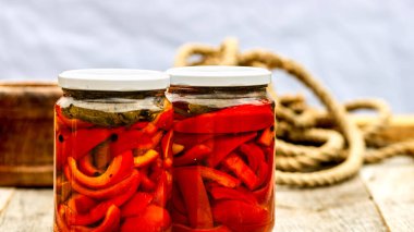 Kırmızı çan biberli cam kavanozlar. Konserve gıda konsepti. Kırsal bir kompozisyonda izole edilmiş konserve sebzeler..