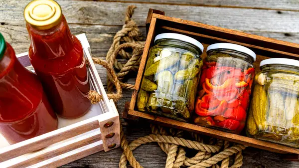 Top view of bottles of tomato sauce, preserved canned pickled food concept isolated in a rustic composition.