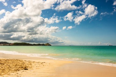 Beyaz kumlu Karayip plajı, derin mavi gökyüzü ve turkuaz su