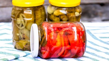 Kırmızı biber turşulu cam kavanozlar ve izole edilmiş salatalık turşusu. Çeşitli sebze turşulu kavanozlar. Kaba bir kompozisyonda yiyecek konseptini korudu.