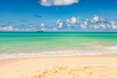 Beyaz kumlu Karayip plajı, derin mavi gökyüzü ve turkuaz su