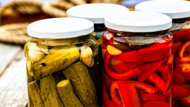 Kırmızı biber turşulu cam kavanozlar ve izole edilmiş salatalık turşusu. Çeşitli sebze turşulu kavanozlar. Kaba bir kompozisyonda yiyecek konseptini korudu.