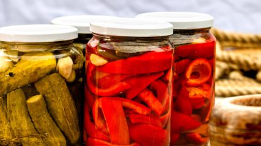 Kırmızı biber turşulu cam kavanozlar ve izole edilmiş salatalık turşusu. Çeşitli sebze turşulu kavanozlar. Kaba bir kompozisyonda yiyecek konseptini korudu.