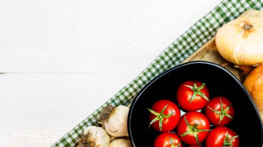 En iyi soğan manzarası, sarımsak ve taze kiraz domatesleri kırsal beyaz ahşap bir masada. Malzemeler ve gıda konsepti
