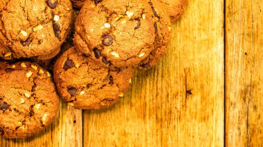 Bisküviler ahşap masada. Masada çikolatalı kurabiye, kahvaltı konsepti. Kopyalama alanı olan üst görünüm