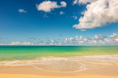 Beyaz kumlu Karayip plajı, derin mavi gökyüzü ve turkuaz su