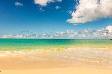 Beyaz kumlu Karayip plajı, derin mavi gökyüzü ve turkuaz su