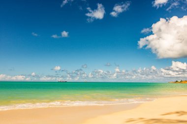 Beyaz kumlu Karayip plajı, derin mavi gökyüzü ve turkuaz su