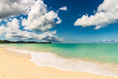 Beyaz kumlu Karayip plajı, derin mavi gökyüzü ve turkuaz su