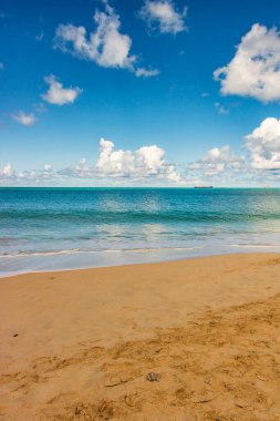 Beyaz kumlu Karayip plajı, derin mavi gökyüzü ve turkuaz su