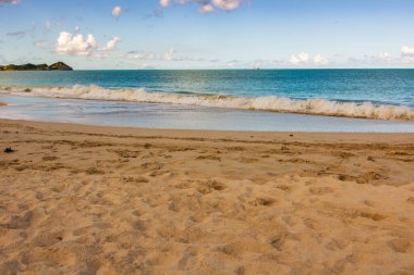 Beyaz kumlu Karayip plajı, derin mavi gökyüzü ve turkuaz su