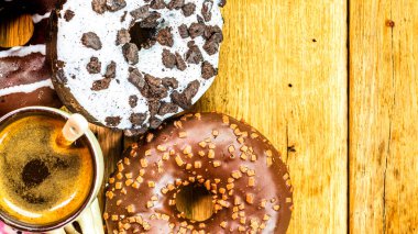 Beyaz ahşap masada renkli çörekler ve kahve fincanı. Jöleli tatlı fırın, kahvaltı konsepti. Kopyalama alanı olan üst görünüm