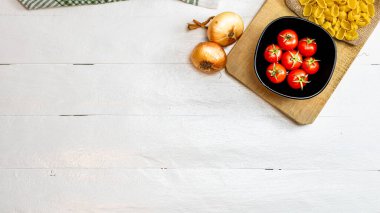 Makarna malzemeleri izole edildi. Çeri domates, makarna, sarımsak ve soğan.