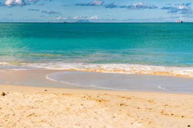 Beyaz kumlu Karayip plajı, derin mavi gökyüzü ve turkuaz su