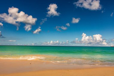 Beyaz kumlu Karayip plajı, derin mavi gökyüzü ve turkuaz su