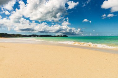 Beyaz kumlu Karayip plajı, derin mavi gökyüzü ve turkuaz su